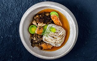 Roasted fillet of Skrei, smoked leeks, confit chicken wings, maitake mushrooms