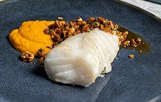 Norwegian skrei with carrot puree, hazelnuts and bacon